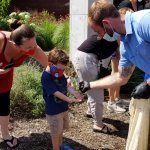 young boy being handed ladybugs