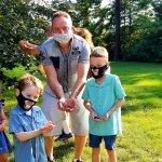 family holding out handful of ladybugs