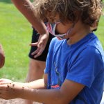 young boy with ladybugs on his arms