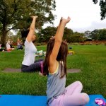 people doing yoga stretch outside on yoga mats