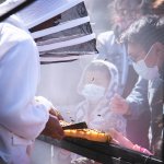 bee keeper showing people honey comb with bees