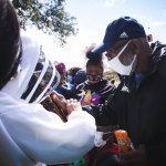 people looking at bees with bee keeper