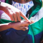 person pointing to bee in hand