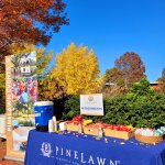 pinelawn table with yellow and red trees in the background