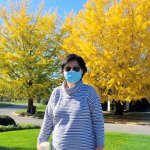 woman standing in front of yellow and green trees