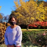 girl standing in front of autumn foliage