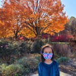 young girl standing in front of orange tree