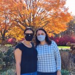 two women standing in front of orange tree