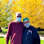 couple standing in front of yellow leaves tree