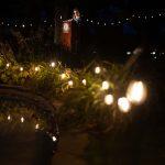 woman speaking at podium outside with lights around her