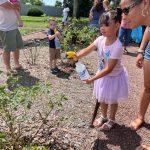 young girl holding spray bottle outside