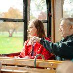 couple sitting on trolley pointing outside window