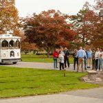 people standing outside with old fashioned trolley in the background