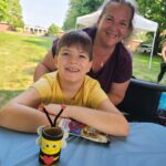 young boy and mother sitting with honey bee arts and craft project