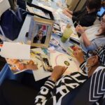 woman creating art project in front of photo of another woman