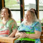 photo of two women smiling while sitting in an old fashioned trolley