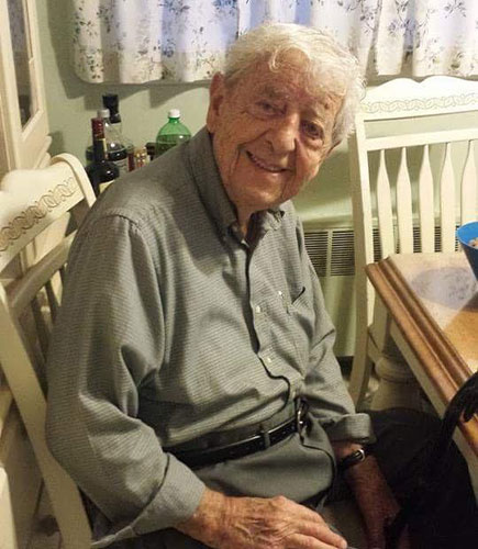 photo of old man sitting at a table smiling