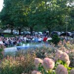 people gathered outside around a fountain sitting