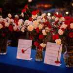 table set with vases filled with roses and cards