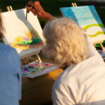 woman painting a landscape on a canvas